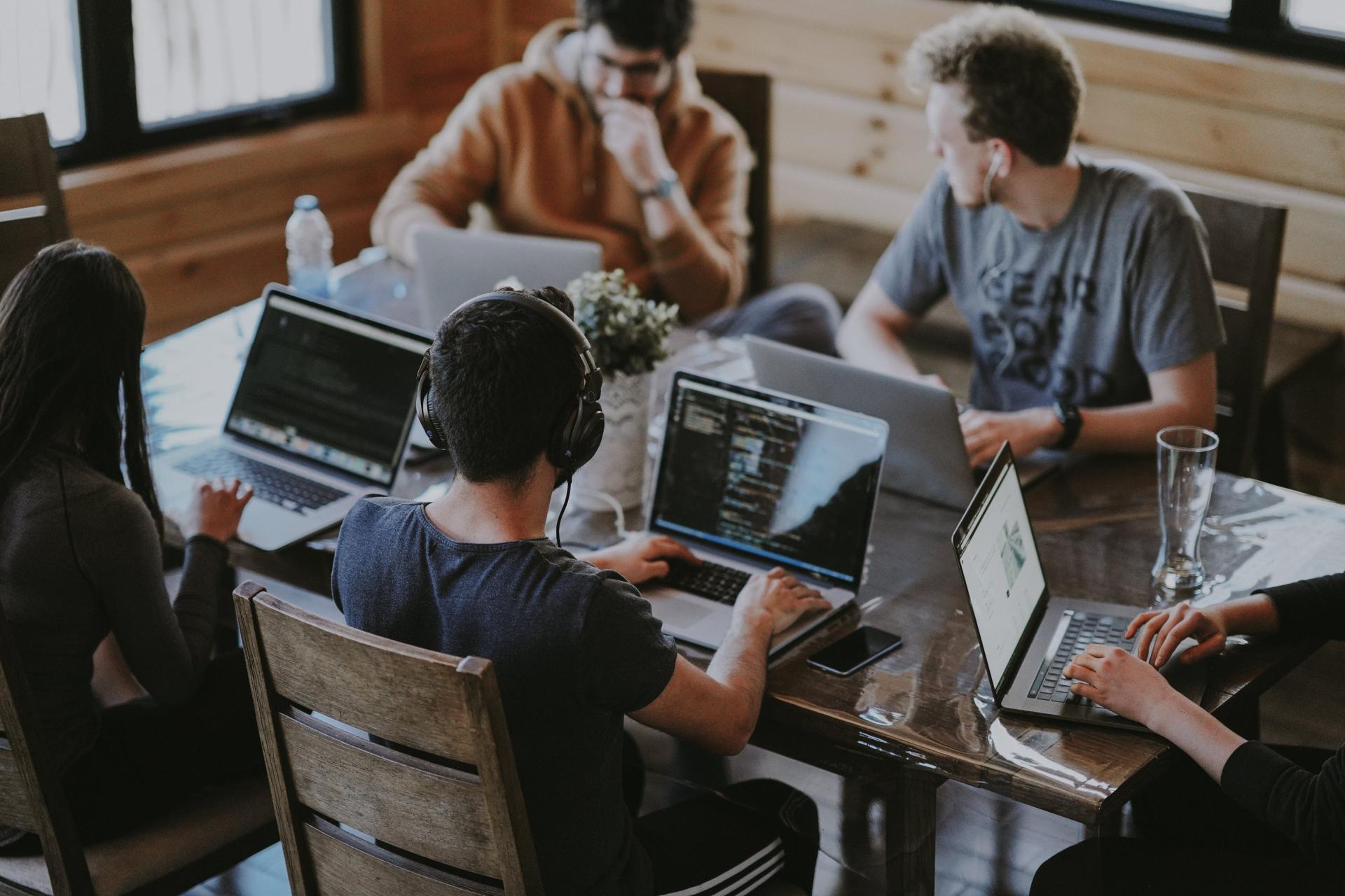People trading on computers around a desk