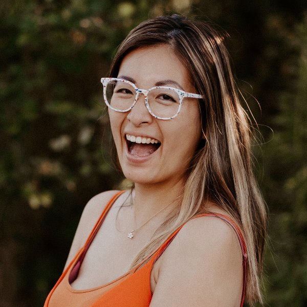 Cassidy Tsang - Asian woman with long hair, glasses, laughing at camera