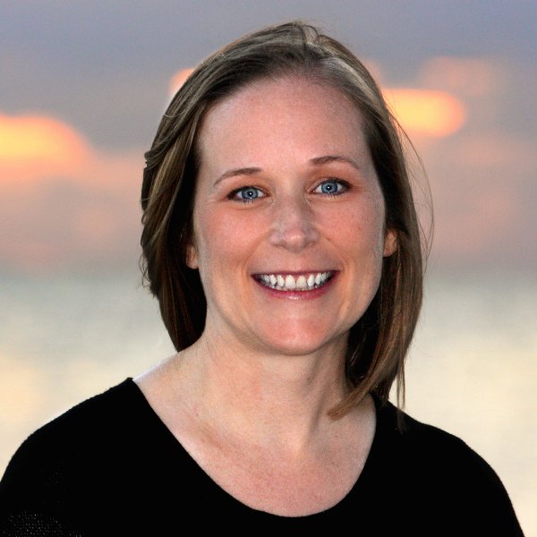 Headshot for Jamie Hand - white woman with shoulder-length straight brown hair, smiling, wearing a black top