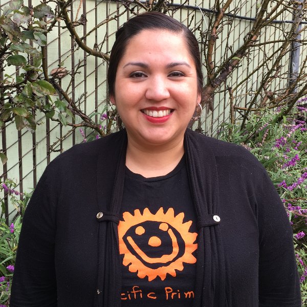 Headshot for Nadia Jaboneta - Peruvian woman with light skin, bright red lips, dark hair pulled back, in a black shirt