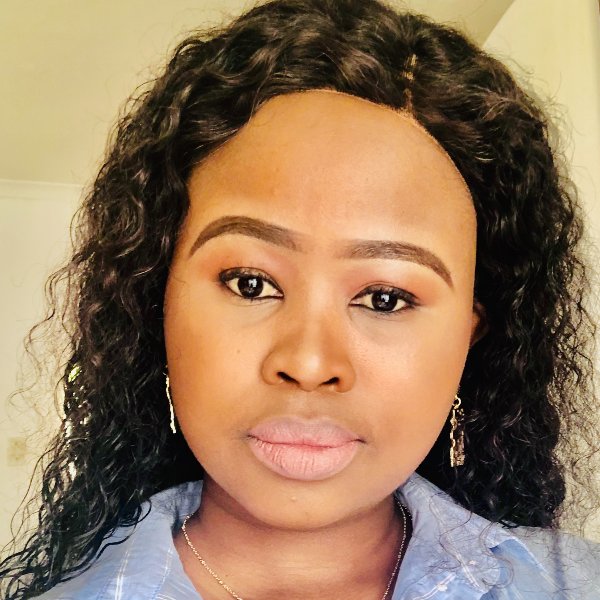 Headshot for Phelisa - a Black woman with curly black hair, looking seriously into the camera, wearing a light blue top