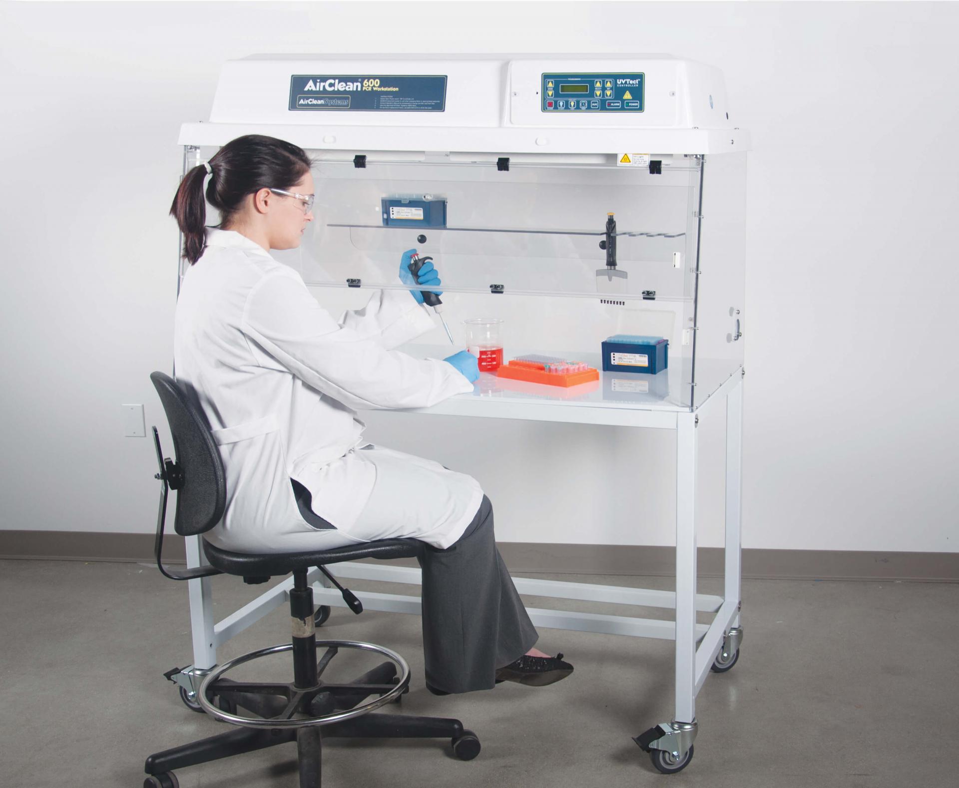 AirClean System PCR workstation with women working a cabinet