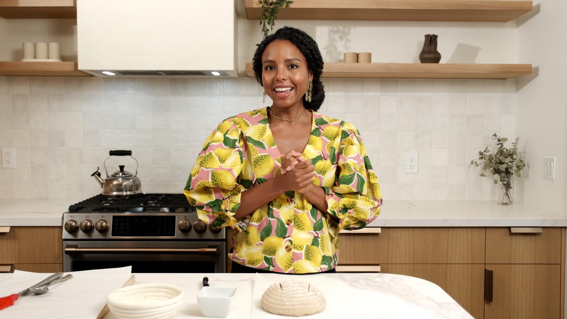 Course instructor standing in front of counter with a ball of bread dough