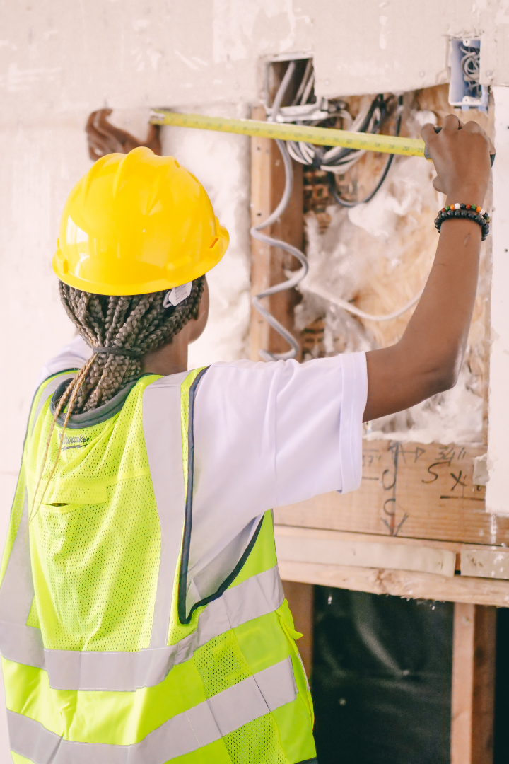 Construction worker using tape measure