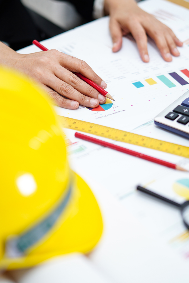Construction owner working on financial graph with tools in office