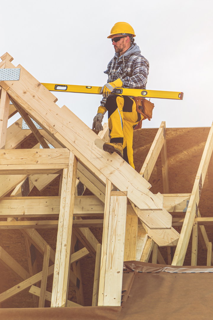 Construction worker on top of wooden roof structure