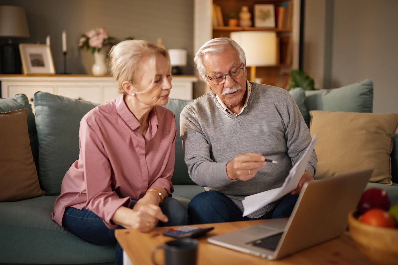 An elderly couple sitting in their living room, considering selling their annuity payments.