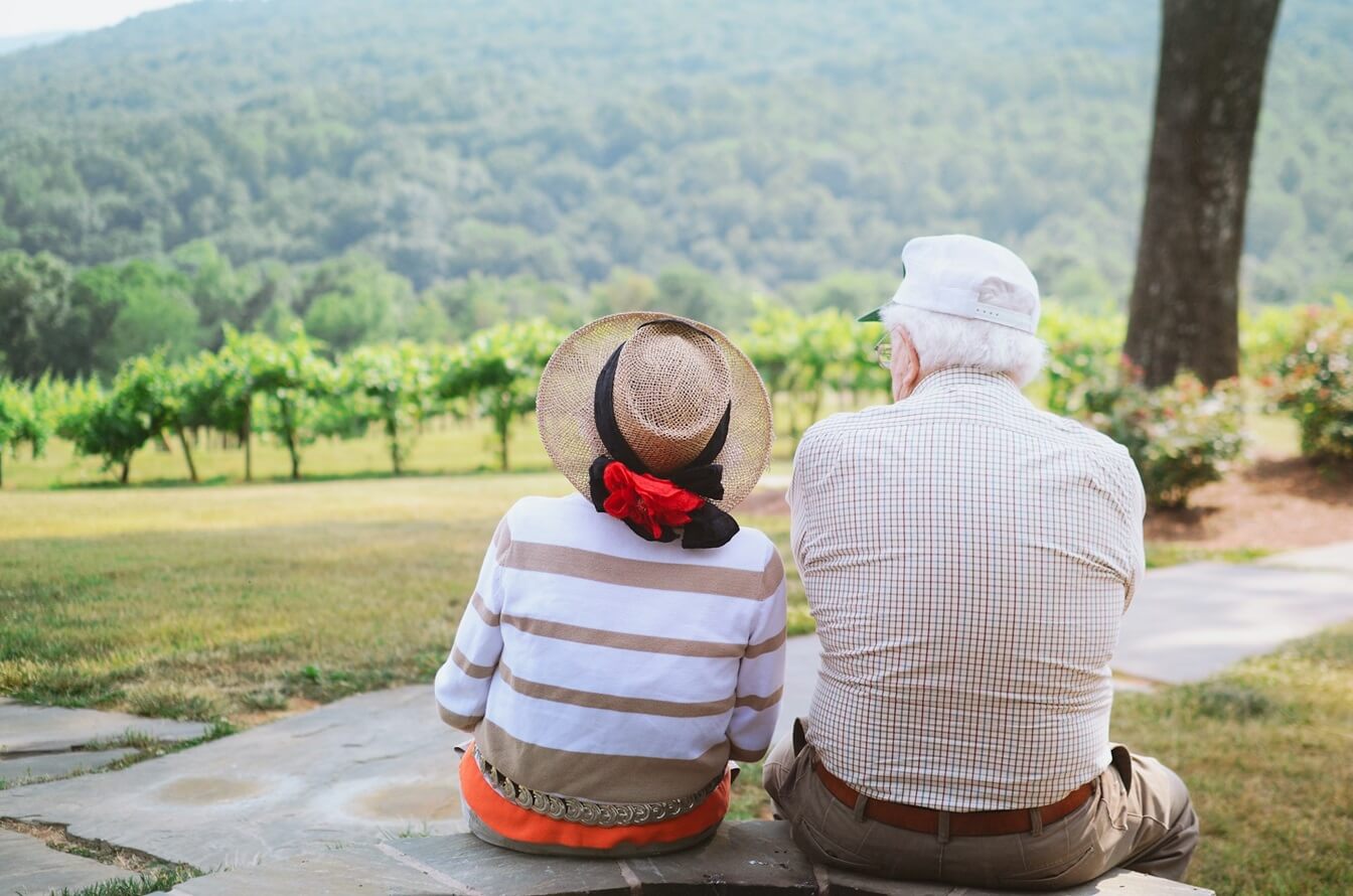 Elderly couple sitting outside and looking at the forest