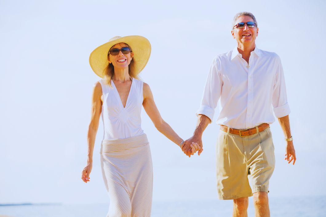 middle-aged couple holding hands on beach