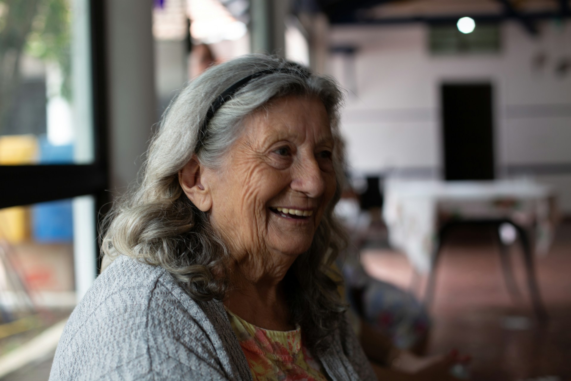 smiling old woman in gray cardigan