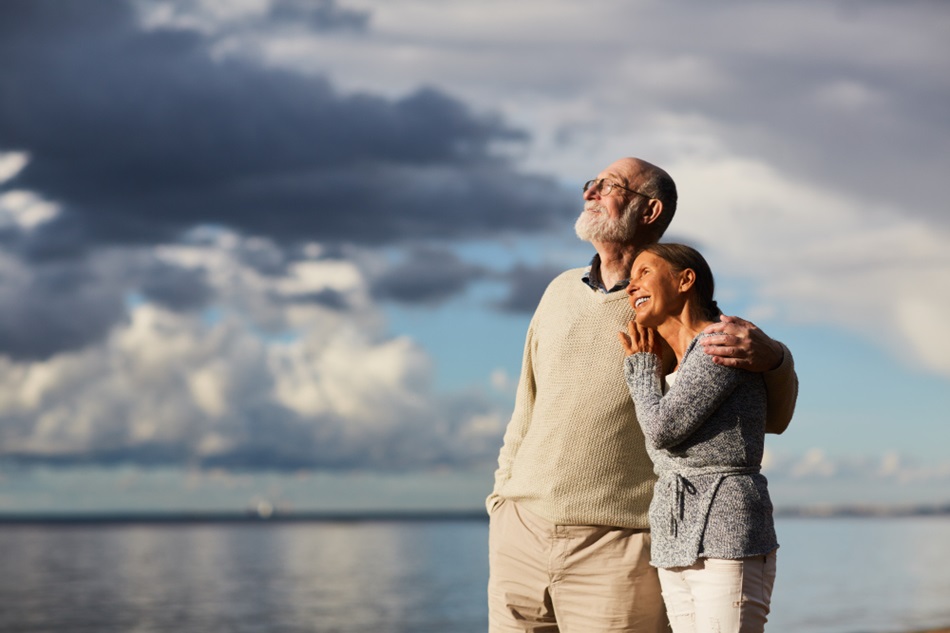 elderly couple standing by the lake