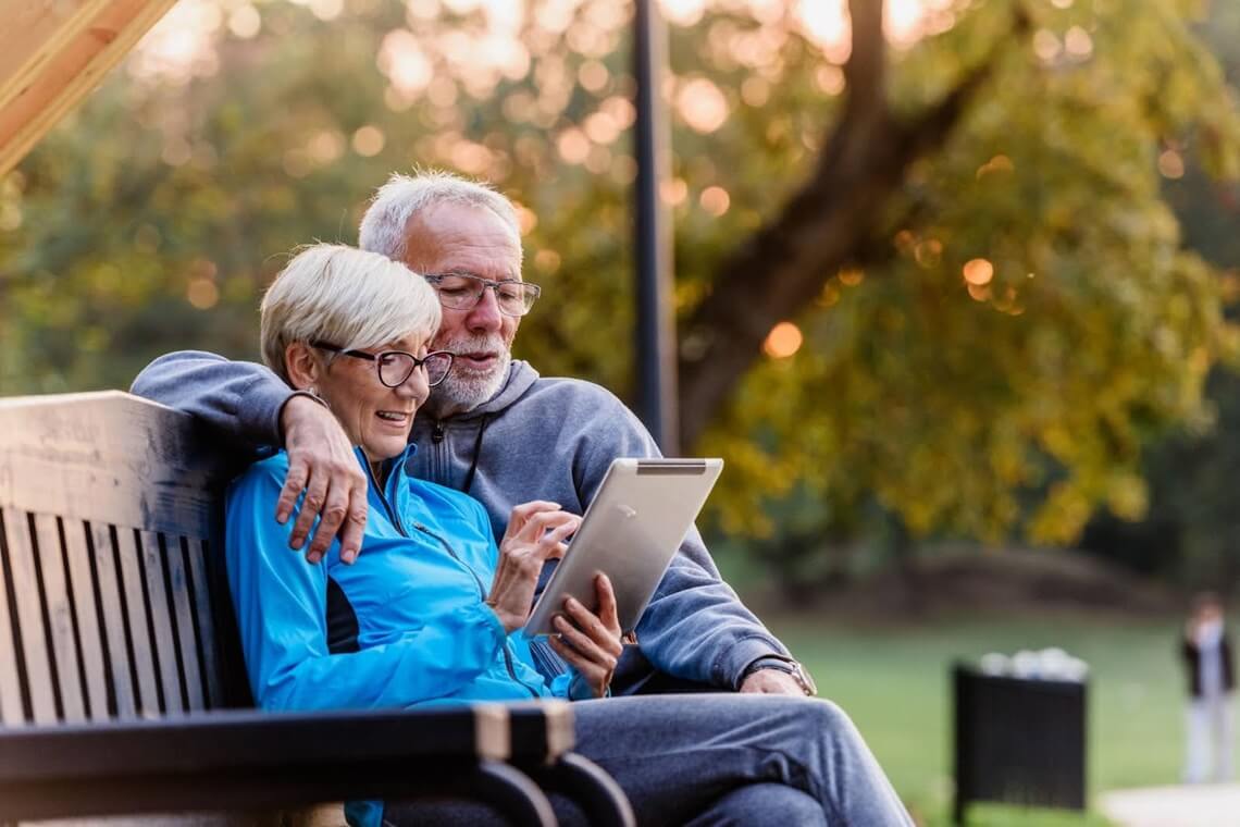 a senior couple reading about annuities on their tablet