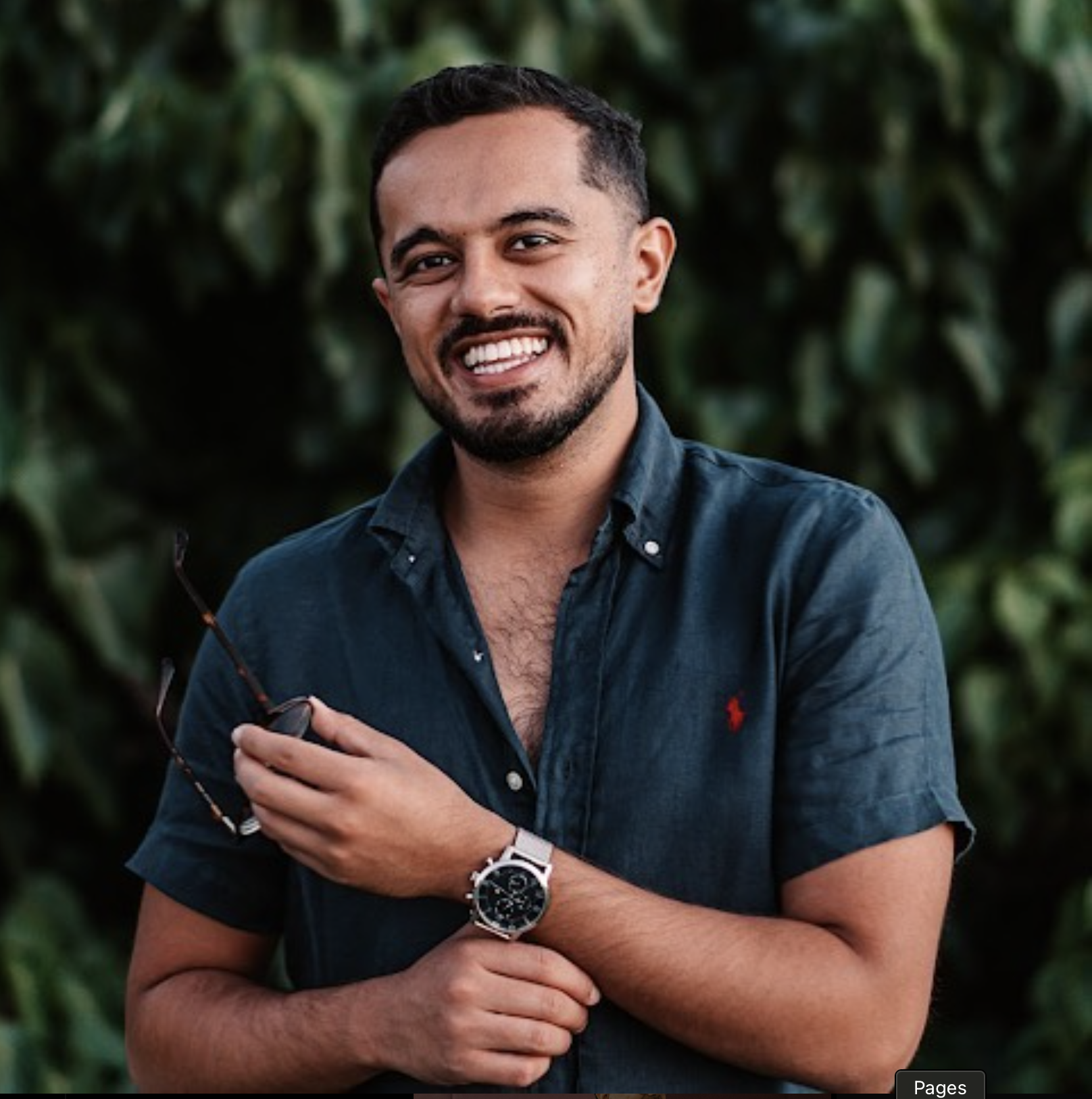 A stylish woman sitting on a stool wearing a hat and jeans.