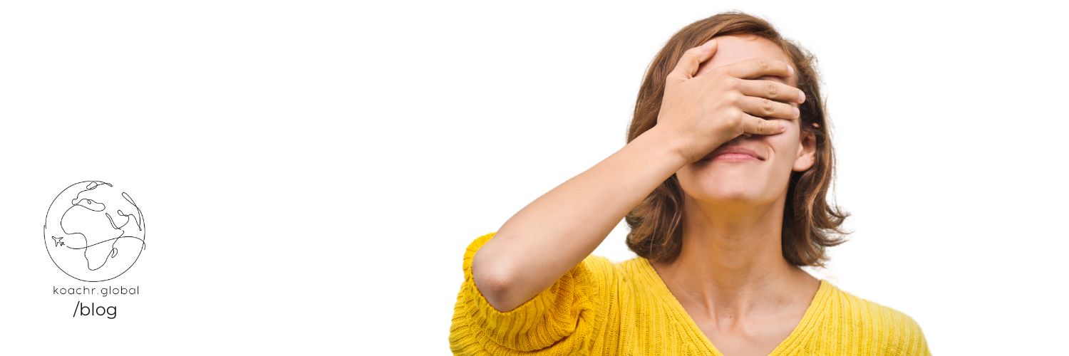 Woman covering her eyes in embarrassment over cultural faux pas..