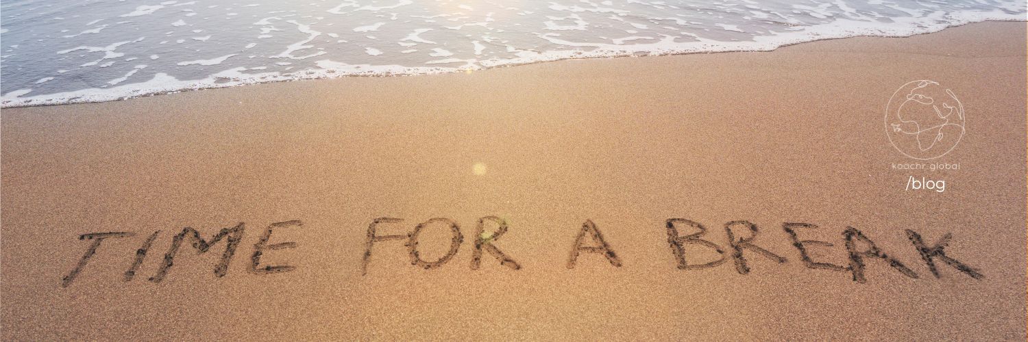 Beach with "TIME FOR A BREAK" written in the sand