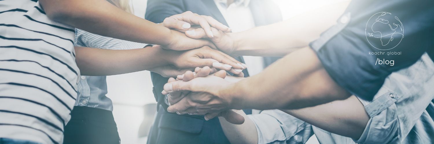 Group of people stacking their hands on top of each other's.