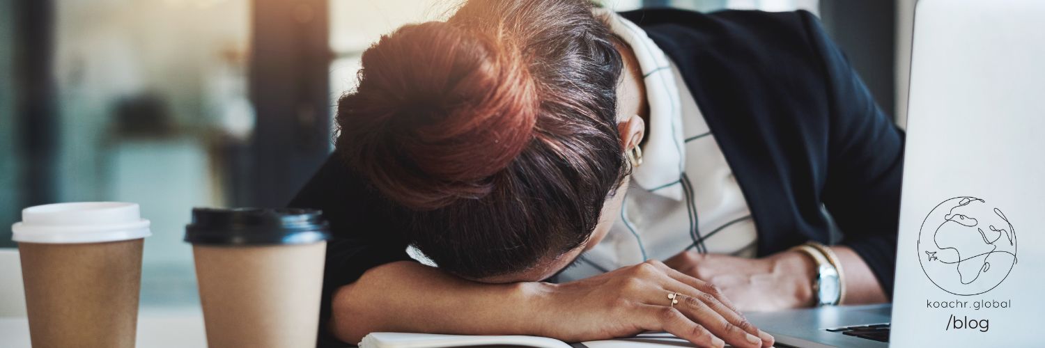Professional woman resting her head on her desk in resignation.