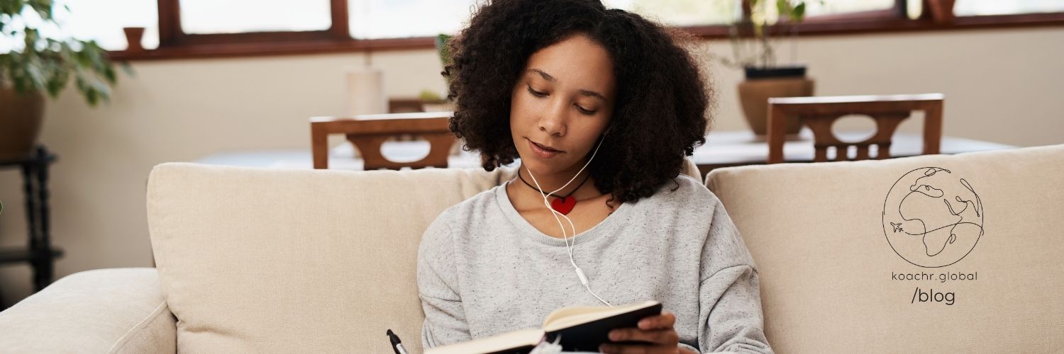 African woman looking calm and content, sitting on a couch and writing in a journal about her dreams of a career in the UN