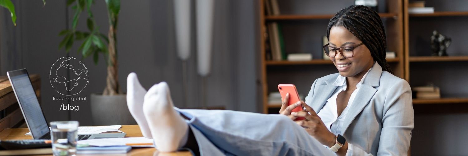 business woman procrastinating with her phone, shoes off, feet up on her desk