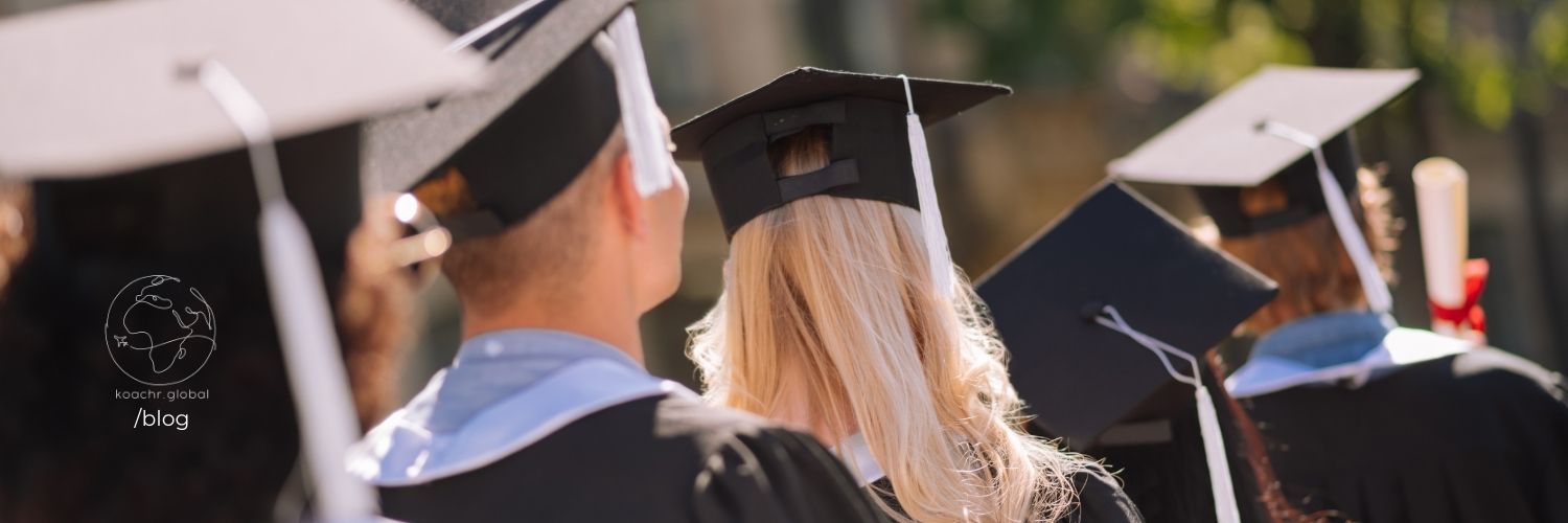 Graduates in their caps and gowns, waiting in a row, picture taken from behind