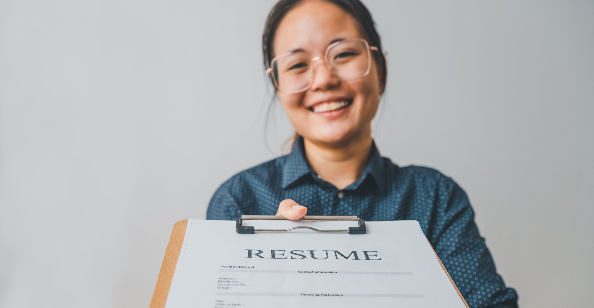 Woman proudly handing over her resume.