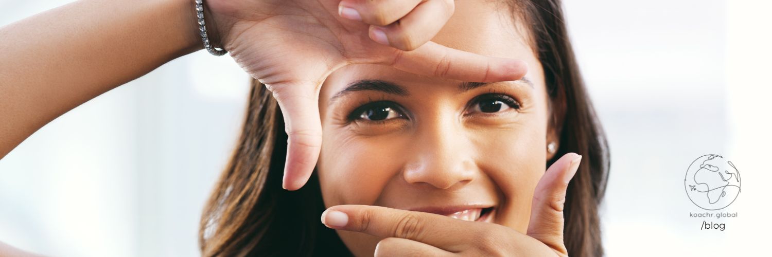 Woman looking through the frame of her hands, creating a rectangle.