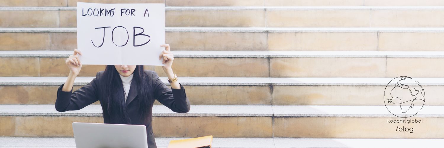 Woman holding up a sign saying "looking for a job"