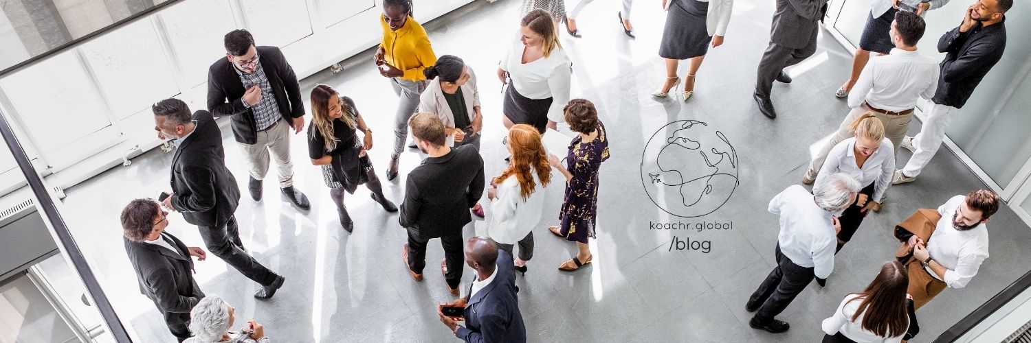 Shot from above, professionals mingling at an event, in a bright room