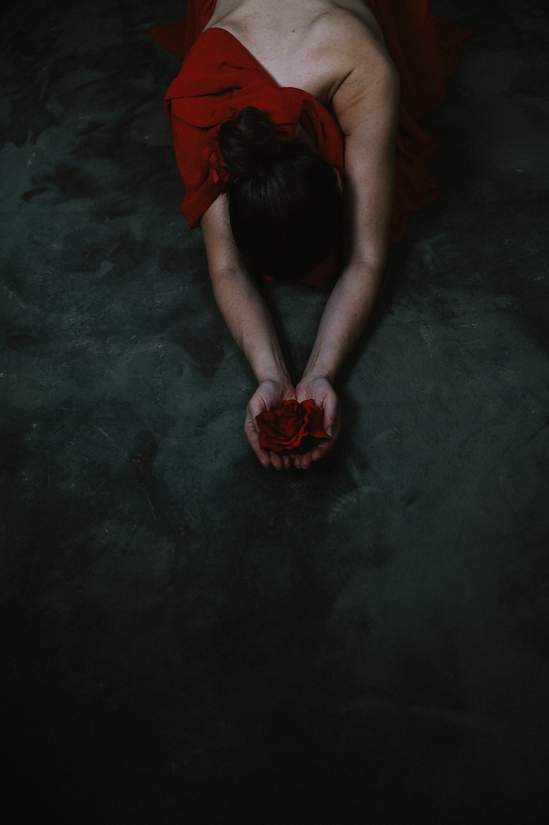 Imagen fine art de mujer arrodillada con vestido rojo en actitud de entrega