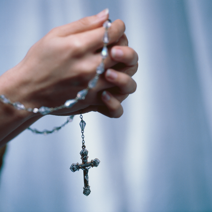 woman praying with a Rosary