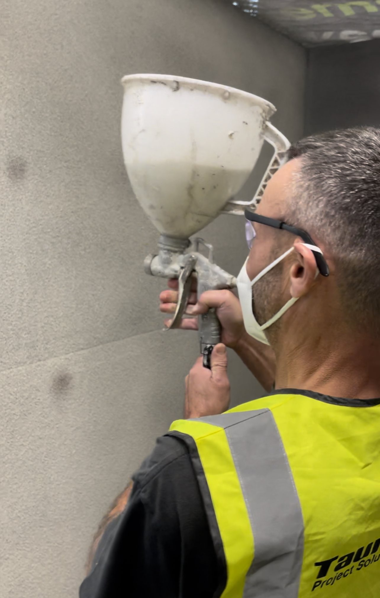 Jack Cook spraying SprayCork insulating coating to a wall