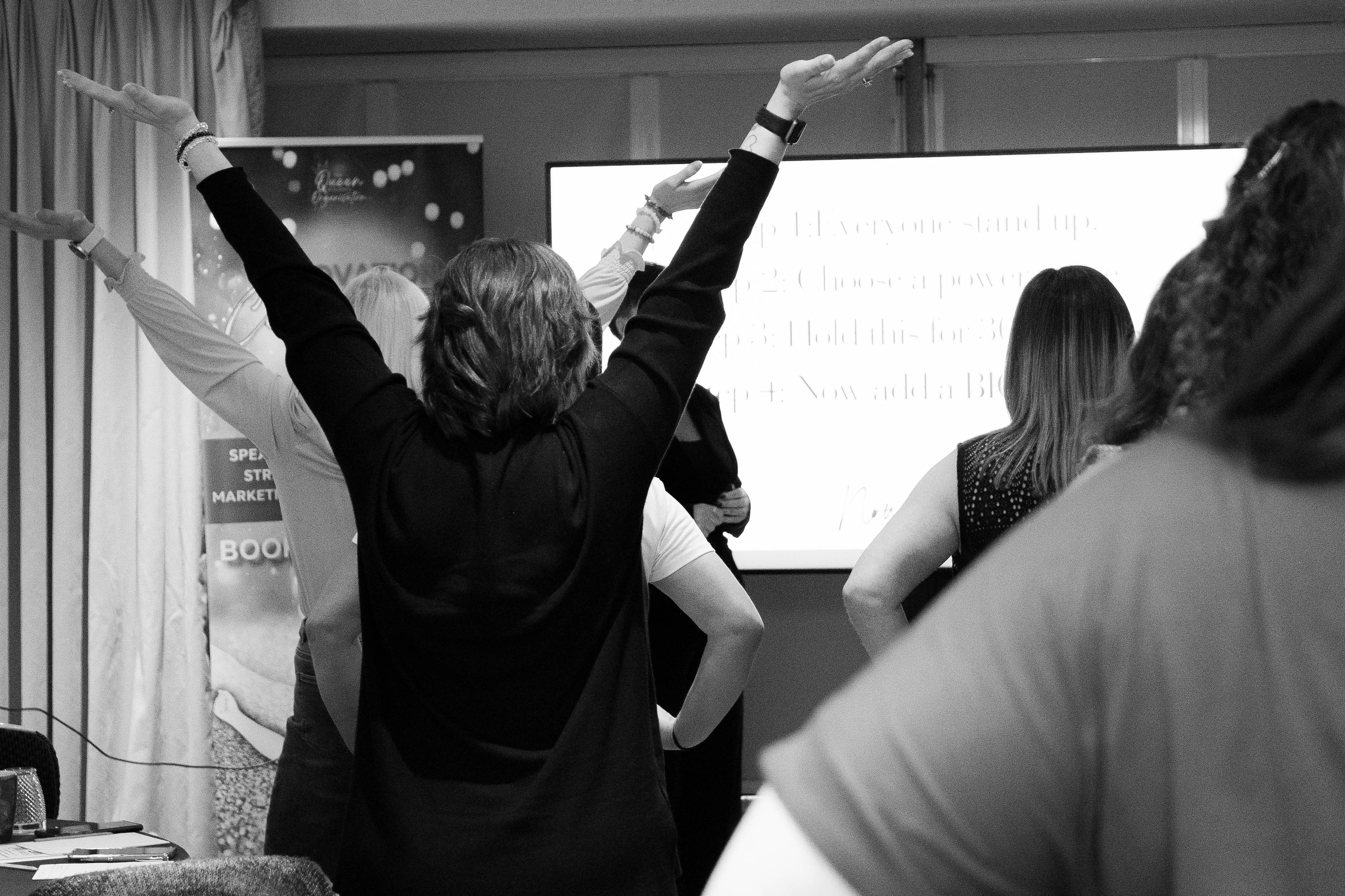 Room of people with hands raised in the air
