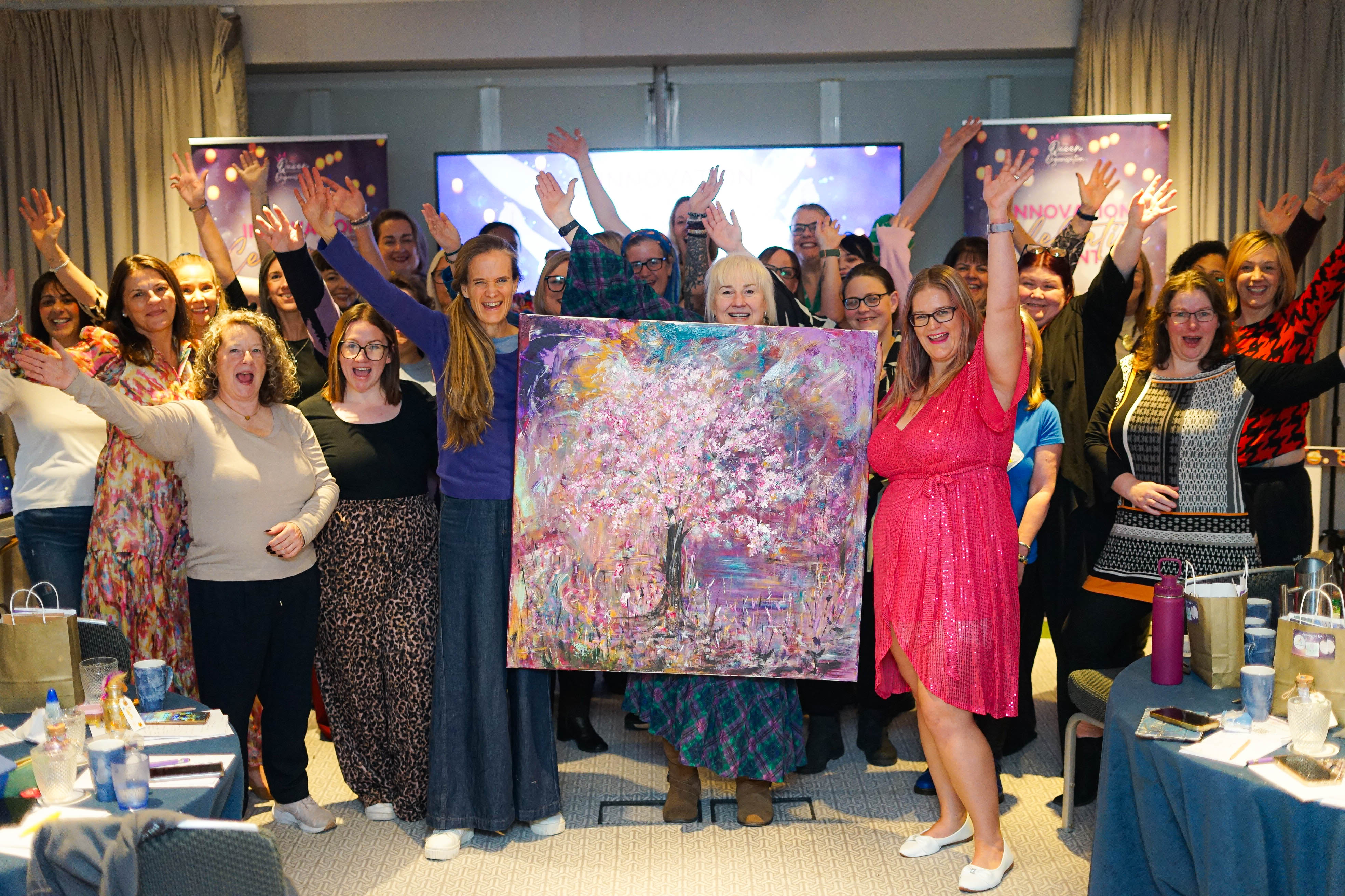Room of people holding a complete painting