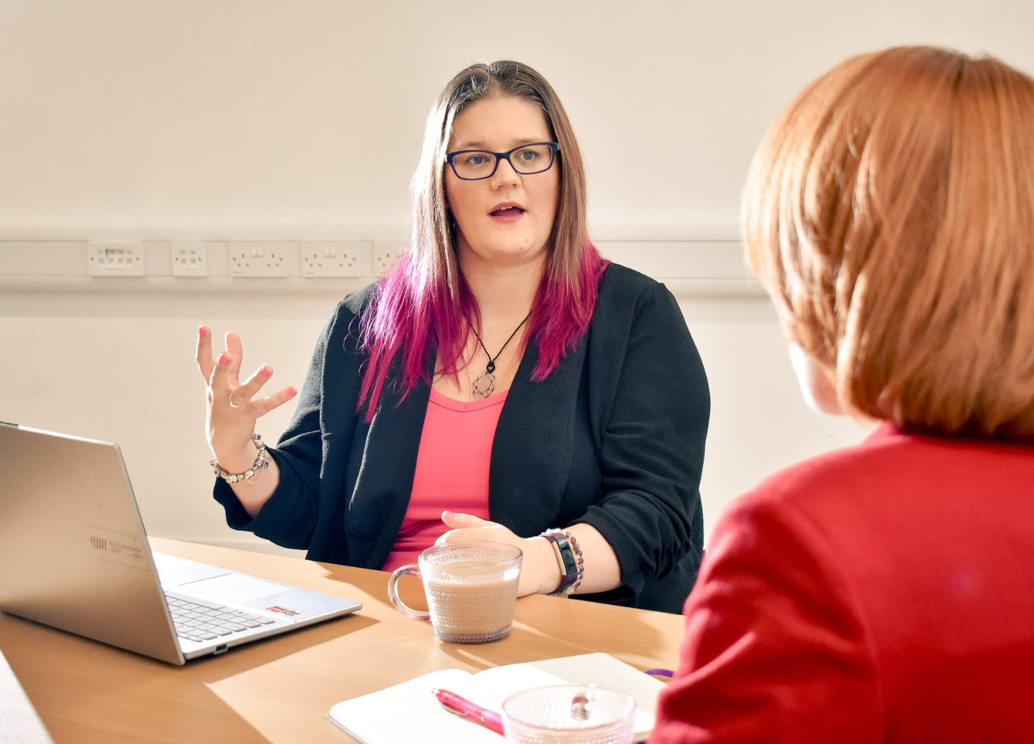 Business coach mentoring a client, sharing strategy and guidance over coffee.