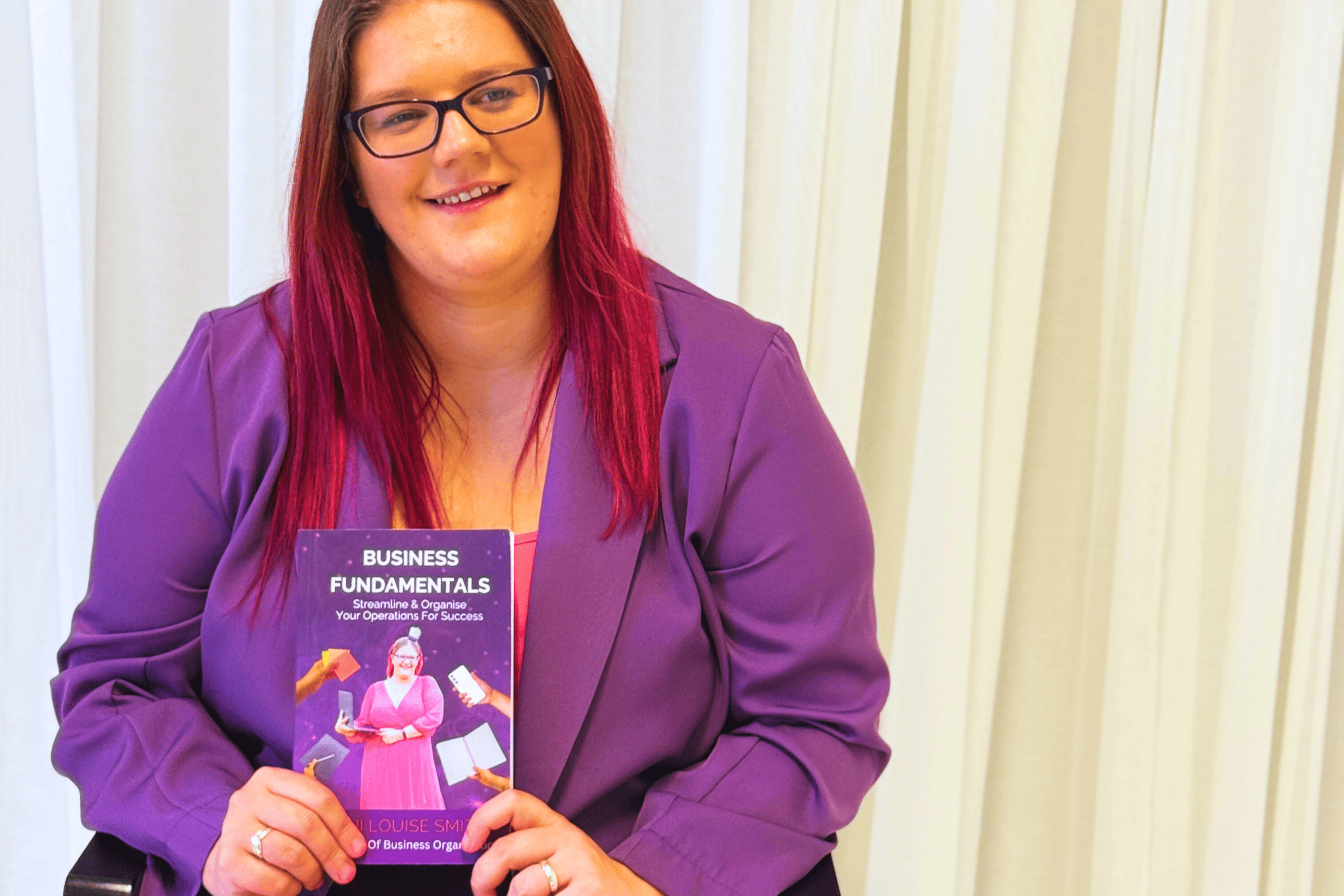 Dani holding her best selling book, Business Fundamentals