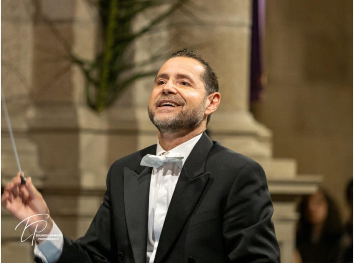 Filipe Ramalhosa Cunha leading an orchestra with expressive gestures on stage during an international concert