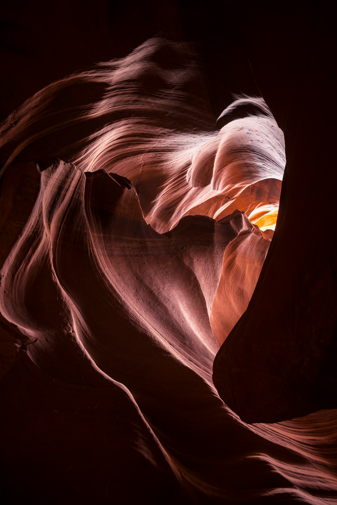 Sun shining through a silhouette in the shape of a heart in red rocks of southern Utah.