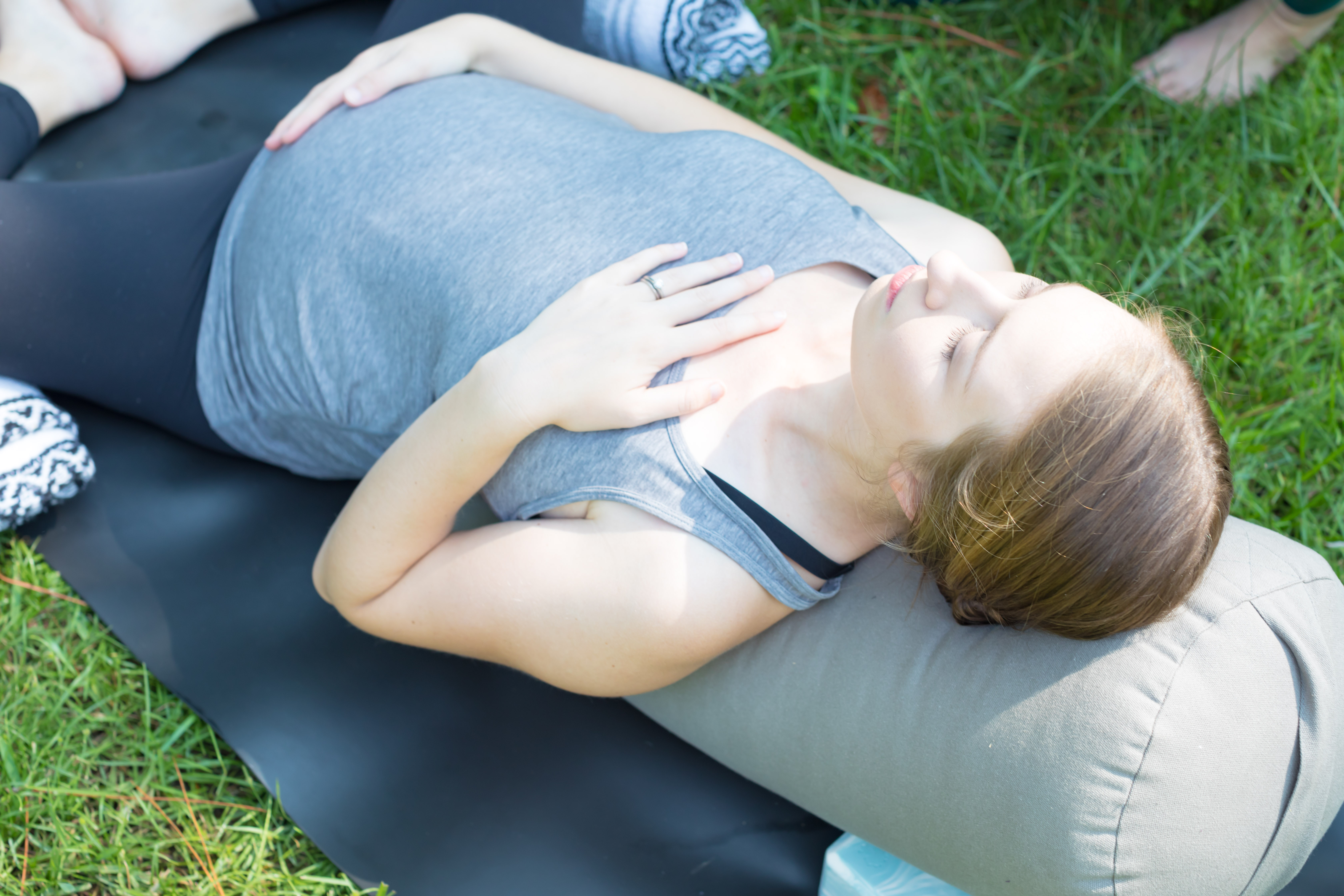 Mother in a restorative yoga pose for pregnancy