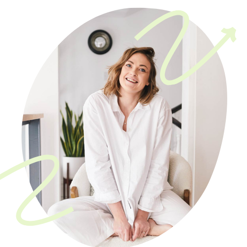 Eine Frau sitzt Lächelnd vor einem Laptop