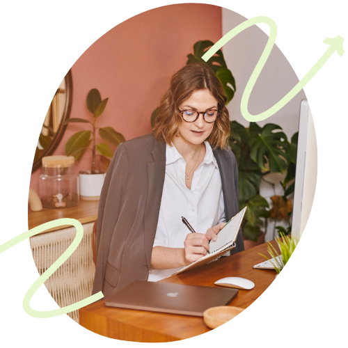 Eine Frau sitzt Lächelnd vor einem Laptop