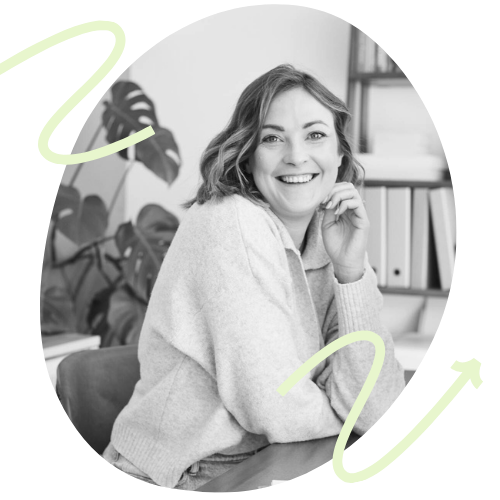 Eine Frau sitzt Lächelnd vor einem Laptop