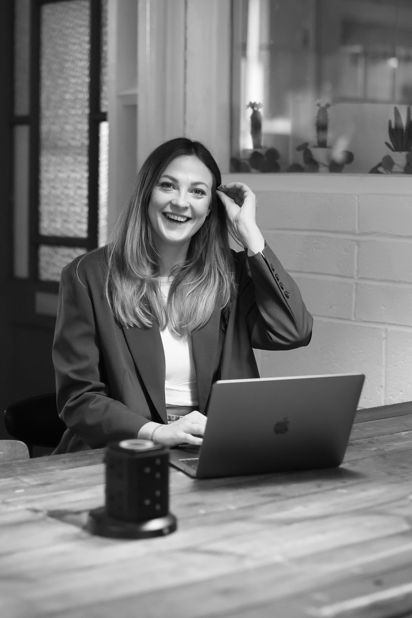 Eine Frau sitzt Lächelnd vor einem Laptop