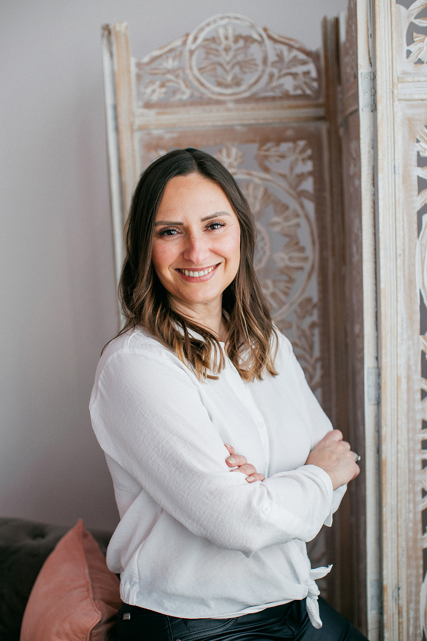 Woman leaning on wall smiling.