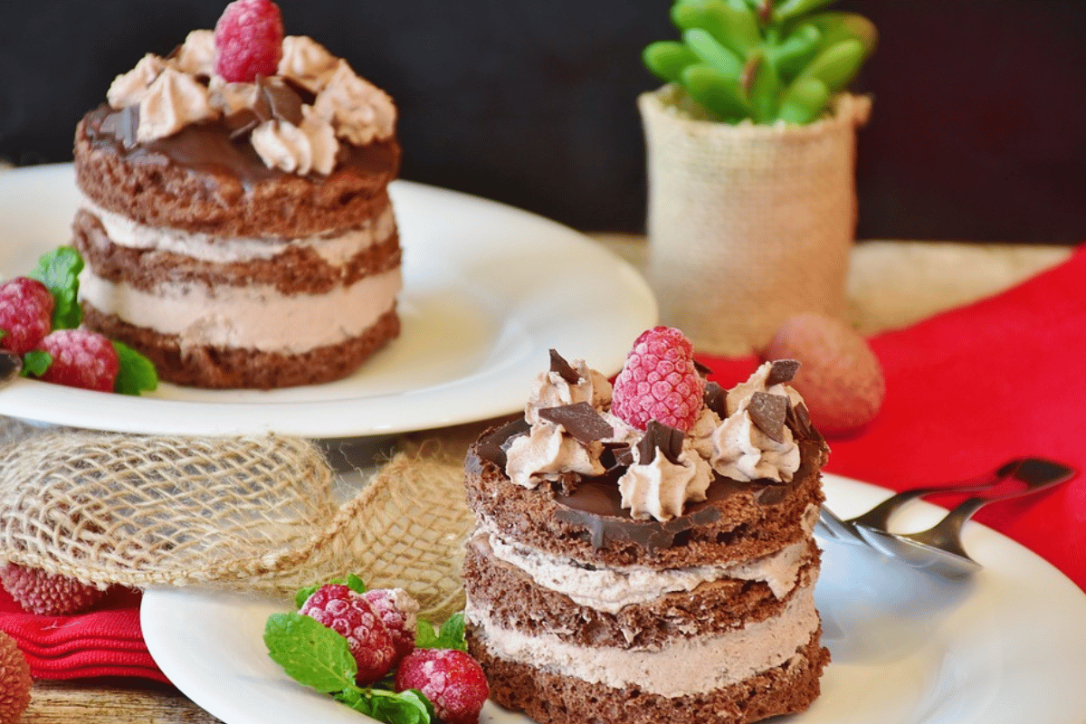a table with plates of whole chocolate cakes and decorations