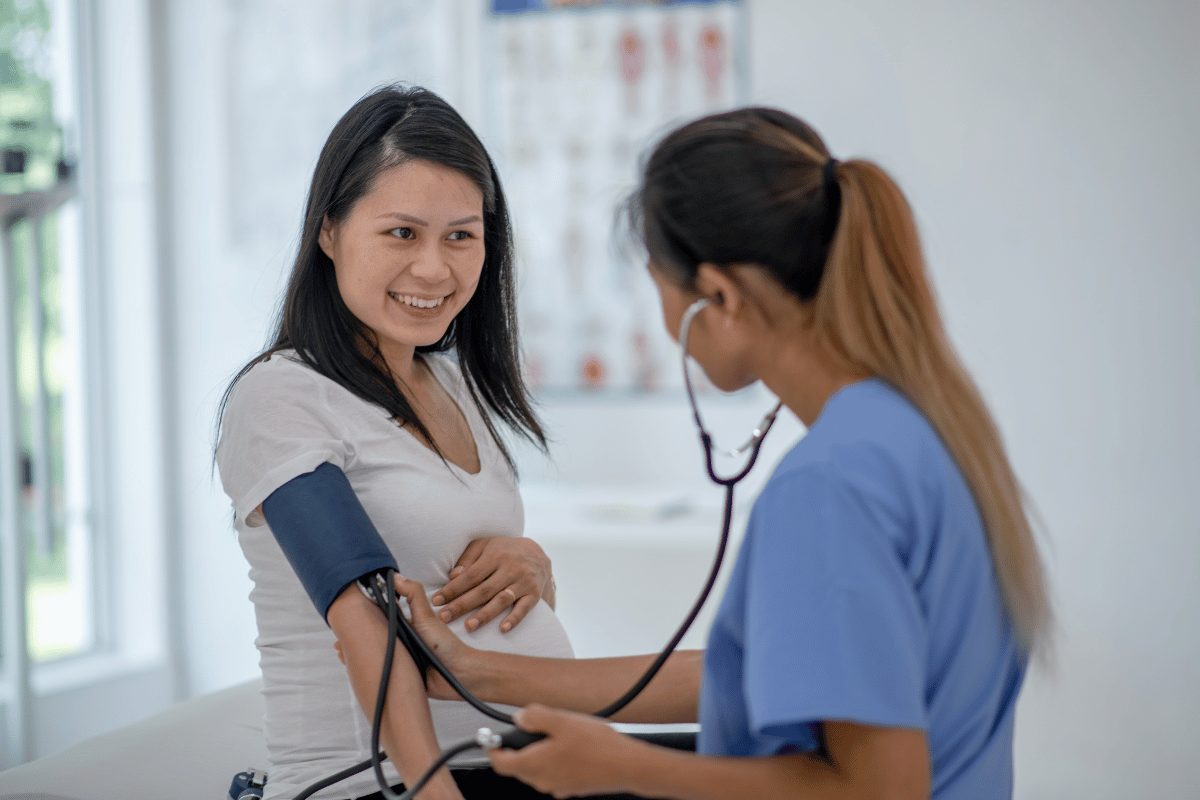 image of pregnant woman having her blood pressure taken by a medical professional