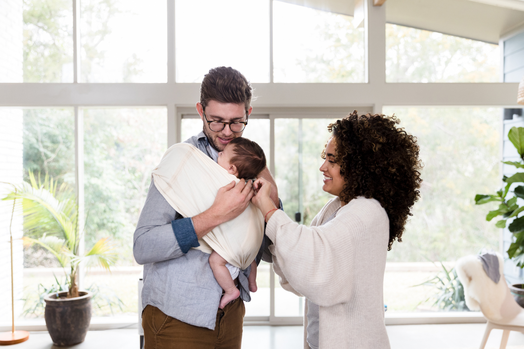 Mum helping dad with baby sling