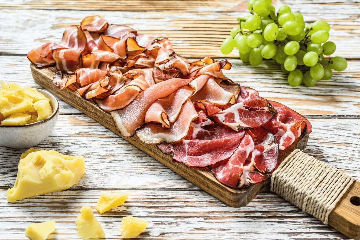 photo of a charcuterie board on a table with a bunch of grapes