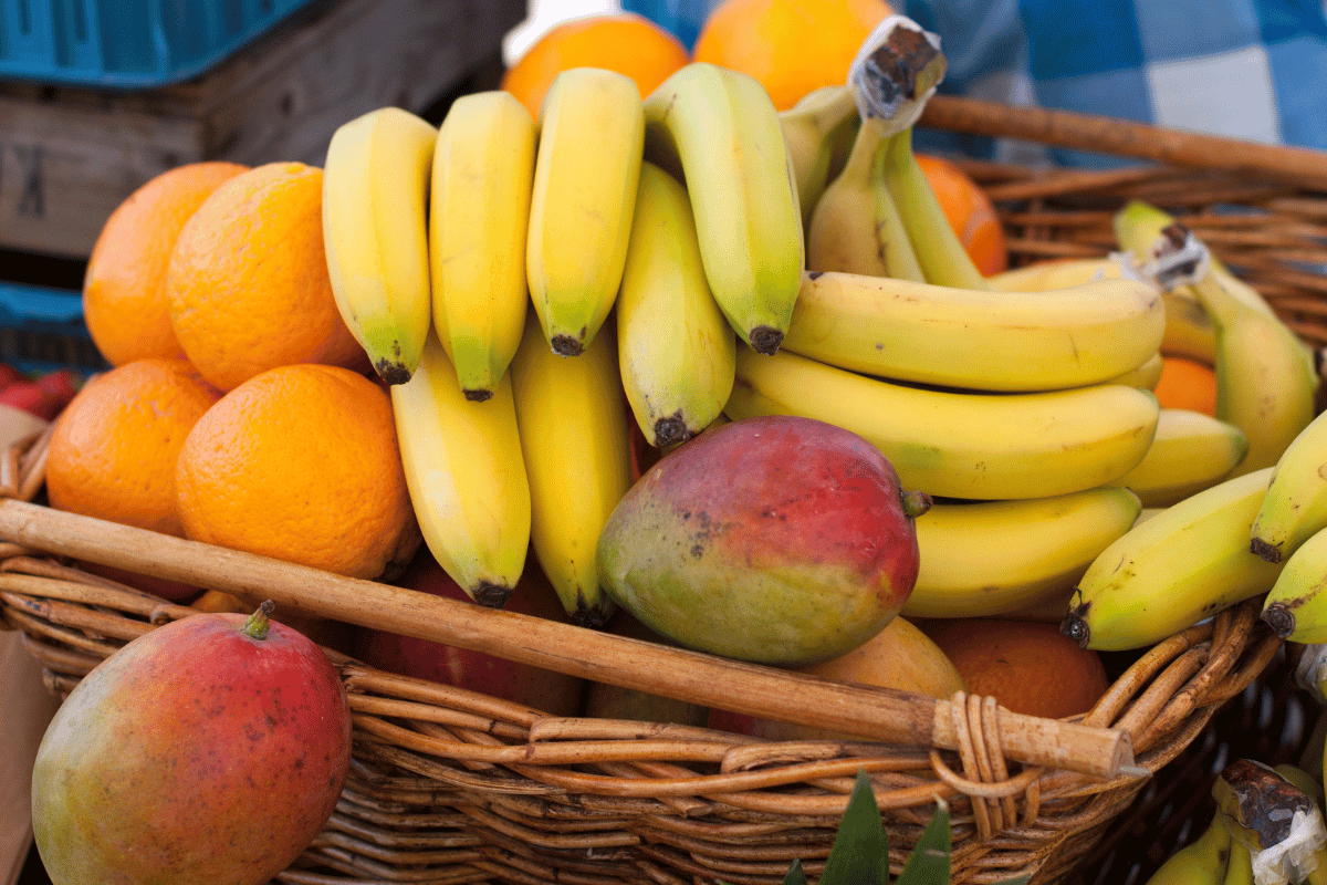 basket of bananas mangos and oranges