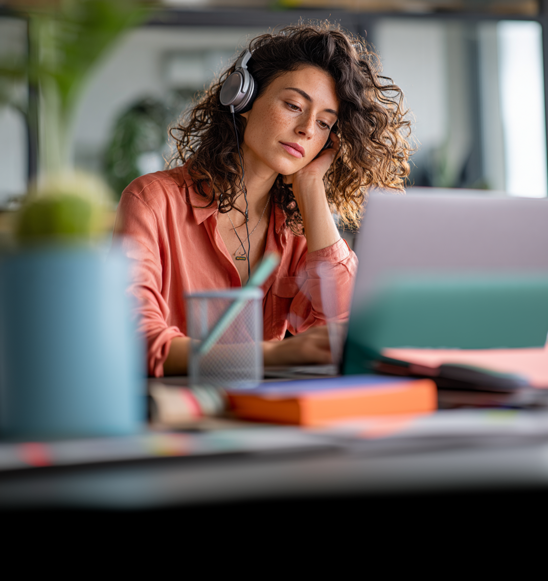 Photo of confident woman leader in a coaching conversation behind her laptop in natural light