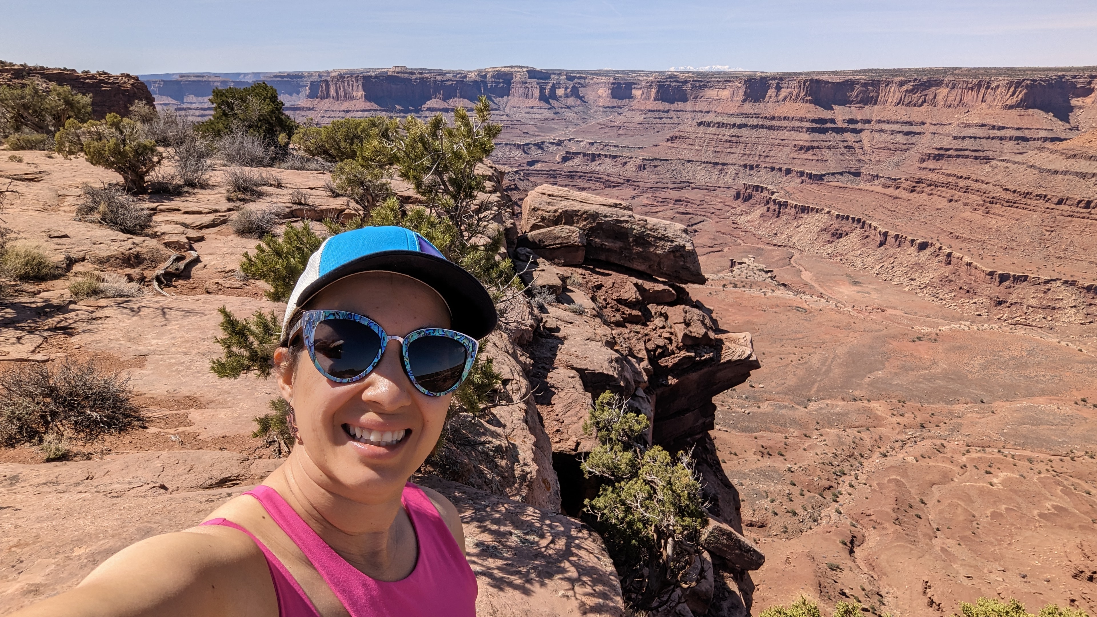A photo of Justina standing in the red desert, overlooking a vast landscape of red sand.